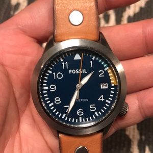 Silver watch with tan leather band.